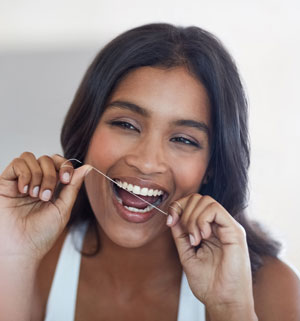 woman flossing to prevent gingivitis